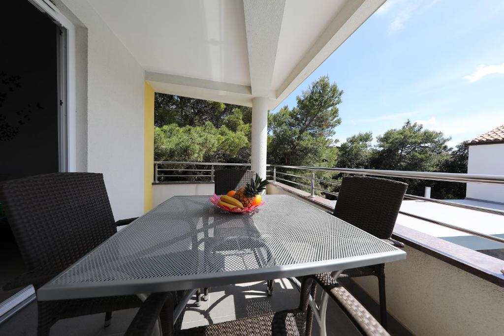 a table with a bowl of fruit on a balcony at Luxury Villa Nada with Pool in Petrcane