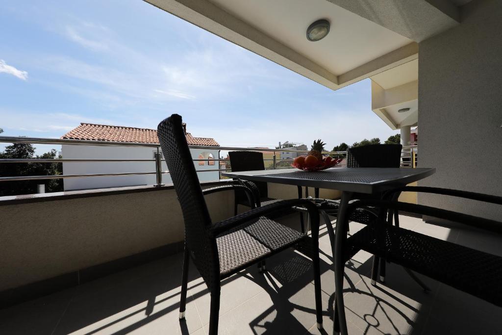 a table and chairs on a balcony with a view at Luxury Villa Nada with Pool in Petrcane
