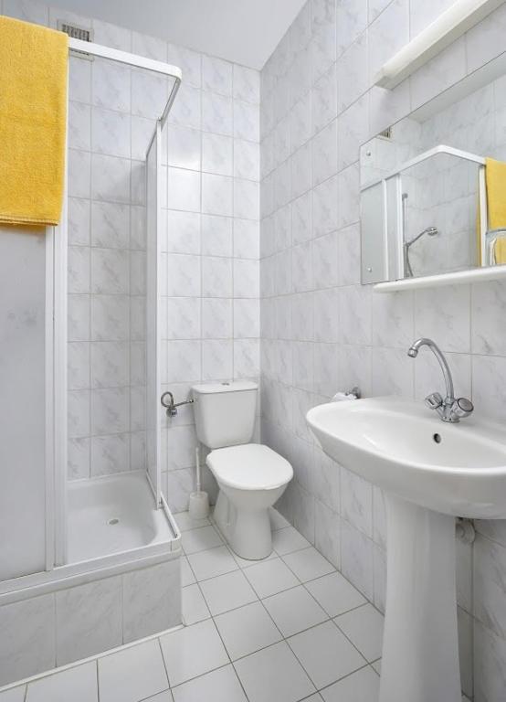 biała łazienka z umywalką i toaletą w obiekcie Vistula Hotel w mieście Świecie