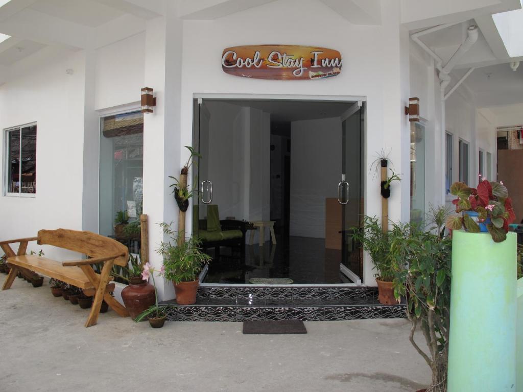 einen Eingang zu einem Gebäude mit einer Bank und Pflanzen in der Unterkunft Cool Stay Inn in Boracay