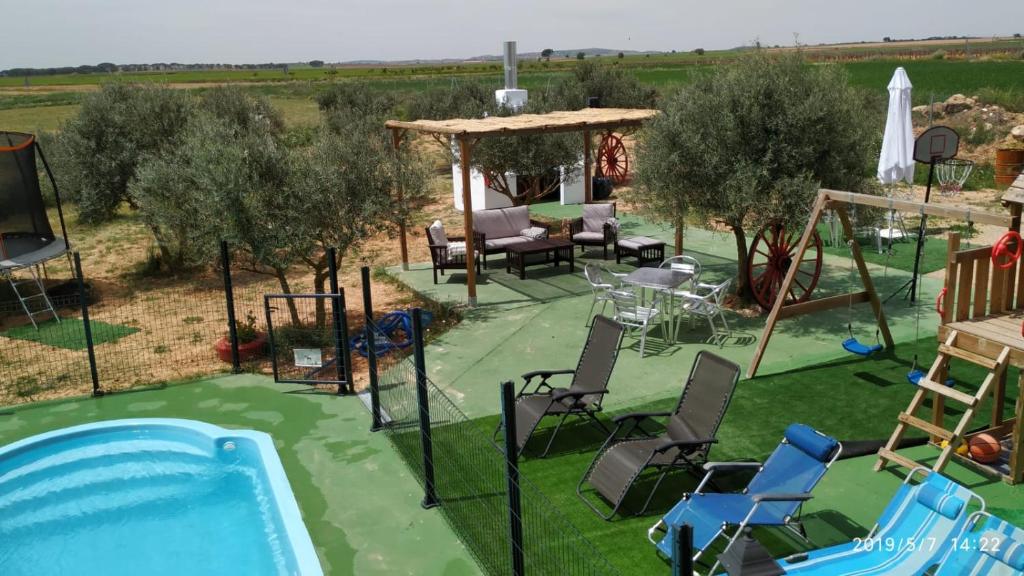 an overhead view of a pool with chairs and a gazebo at Casas Rurales Villa Vicenta in Alcalá del Júcar