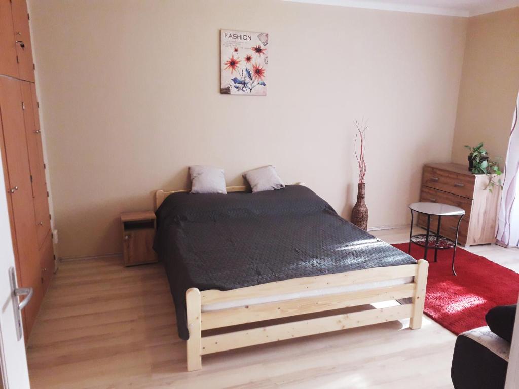 um quarto com uma cama de madeira num quarto em Centrum apartman em Szolnok