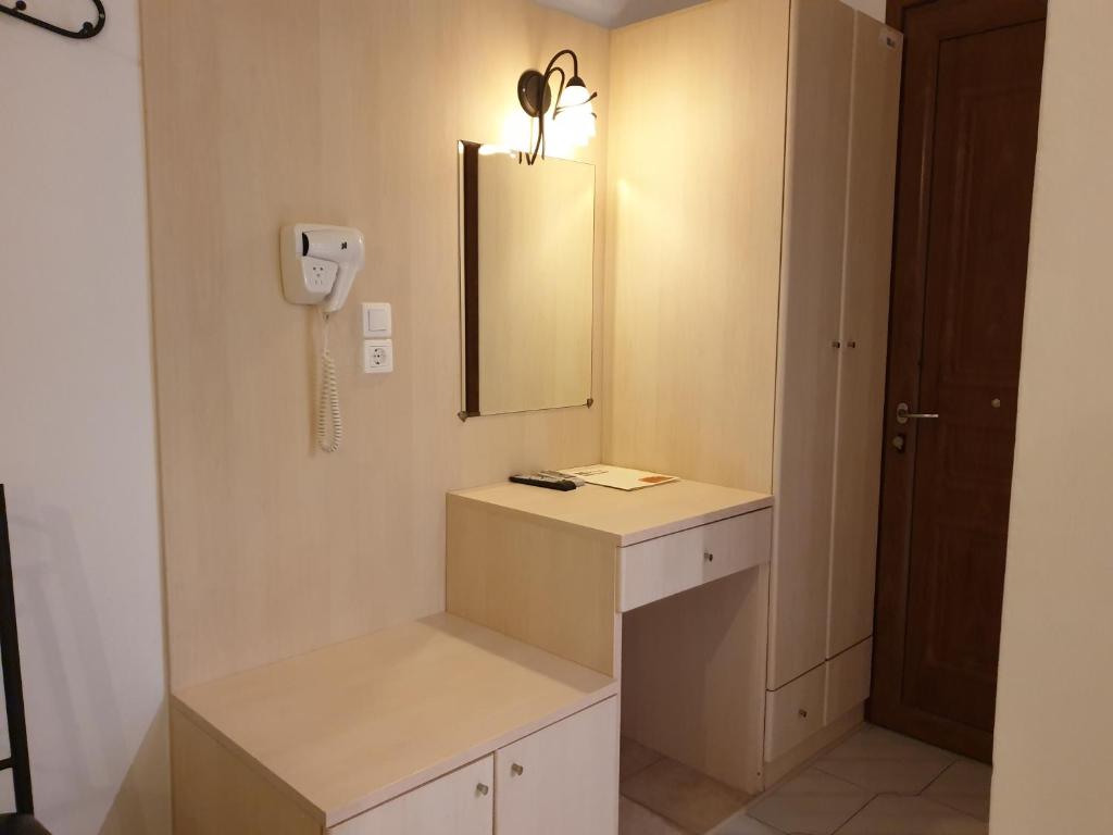 baño con lavabo, espejo y teléfono en Sifnos Hotel Benaki, en Platis Yialos Sifnos