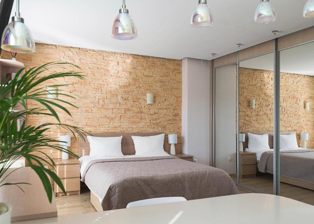 a bedroom with a bed and a brick wall at Royal Garden Apartment in Warsaw