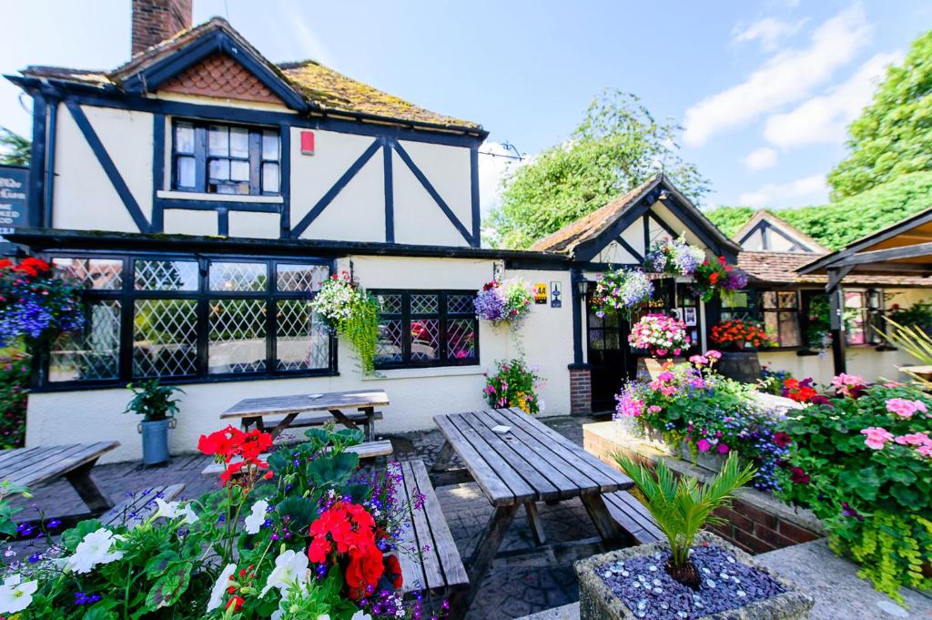 Ein Haus mit einem Haufen Blumen davor in der Unterkunft Ye Olde Red Lion in Newbury