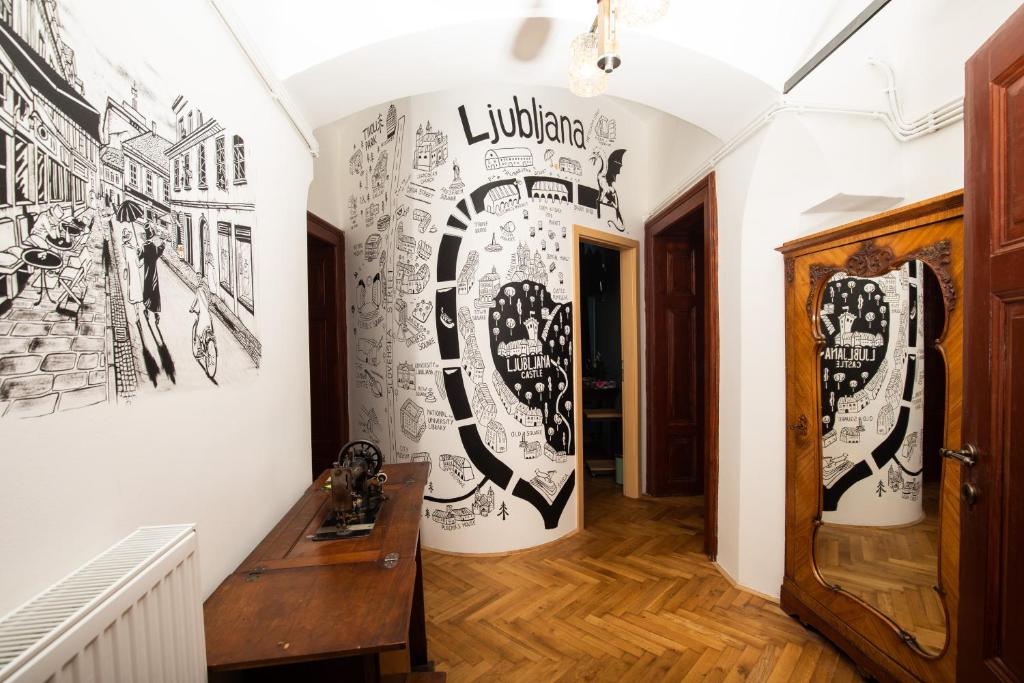 korytarz z czarno-białymi rysunkami na ścianie w obiekcie Dežnik w Lublanie