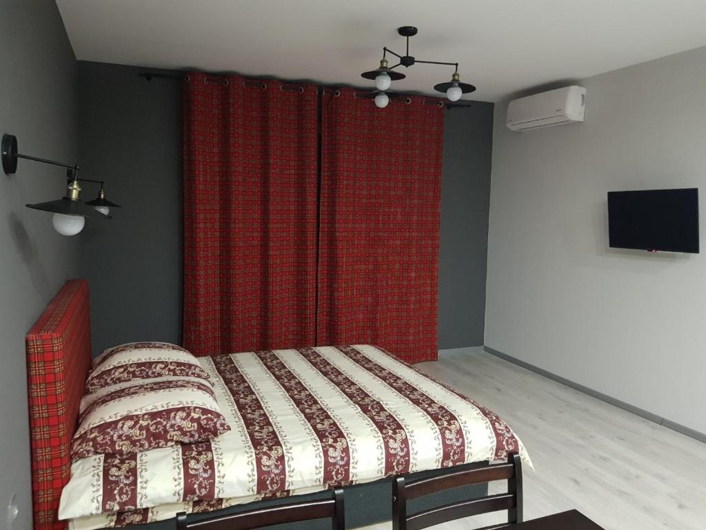 una camera con letto e tenda rossa di Апартаменты Yes Silver a Užhorod