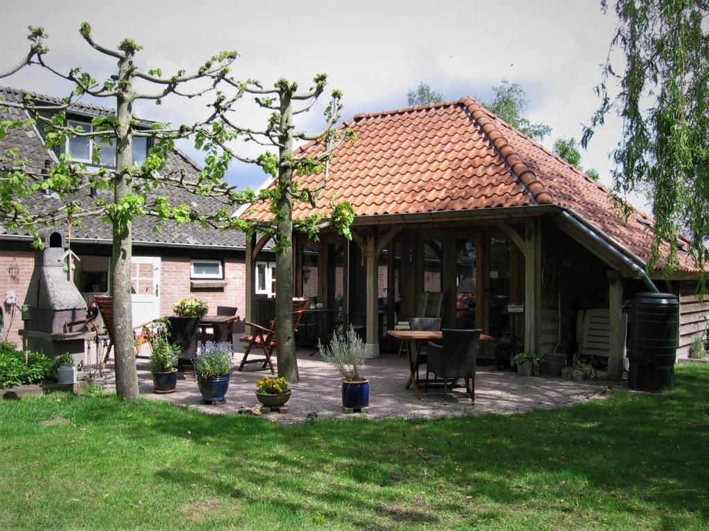 een paviljoen met een tafel en stoelen in een tuin bij Bed&Breakfast 't Eikeltje in Hollandscheveld