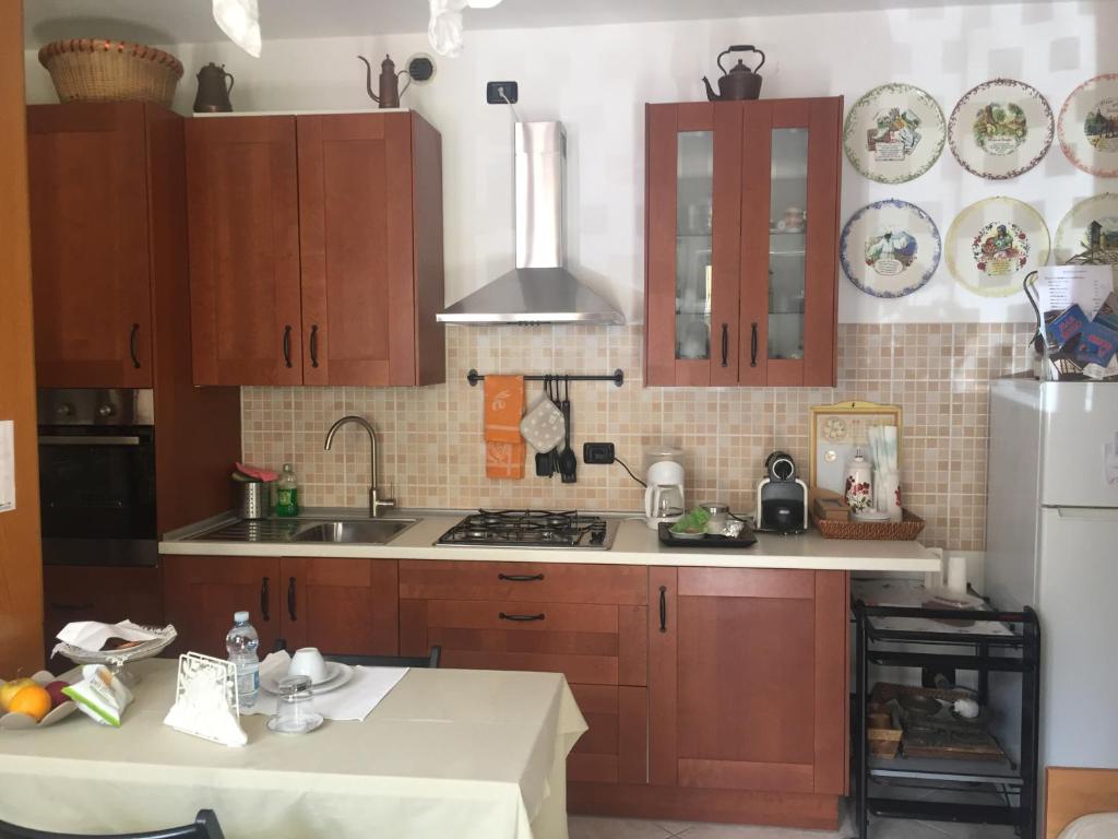 - une cuisine avec des placards en bois et un réfrigérateur blanc dans l'établissement B&B Il Portico del Conte, à Bosisio Parini