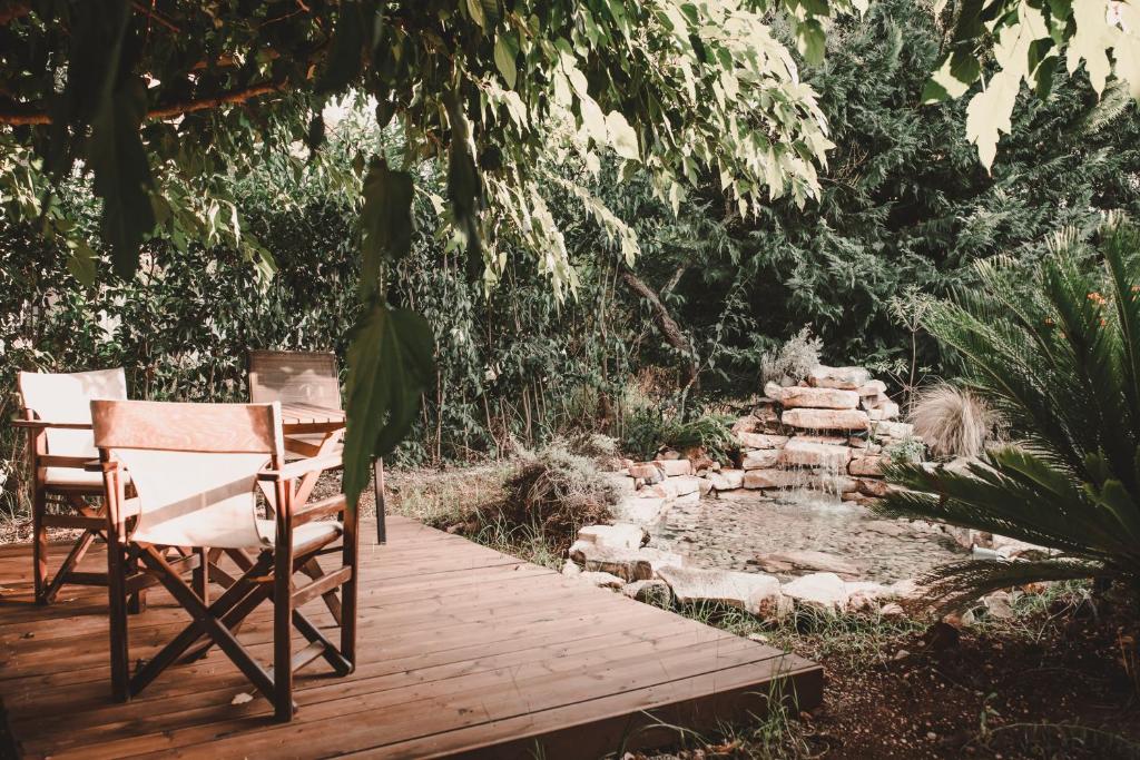 a deck with chairs and a pond in a garden at Aventora Apartments in Lygia