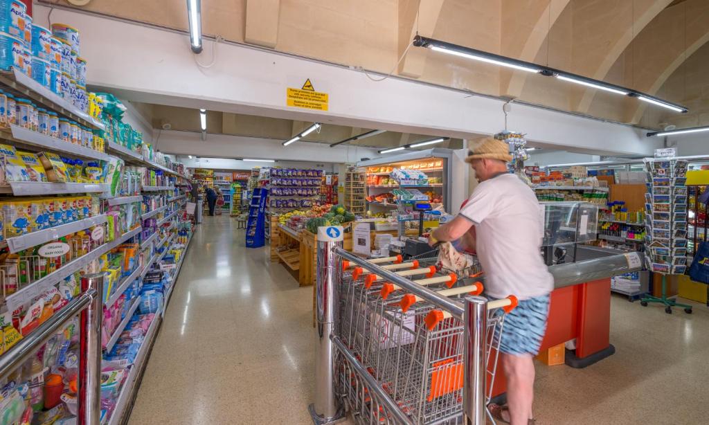 a man is grocery shopping in a supermarket at Mellieha Holiday Centre in Mellieħa