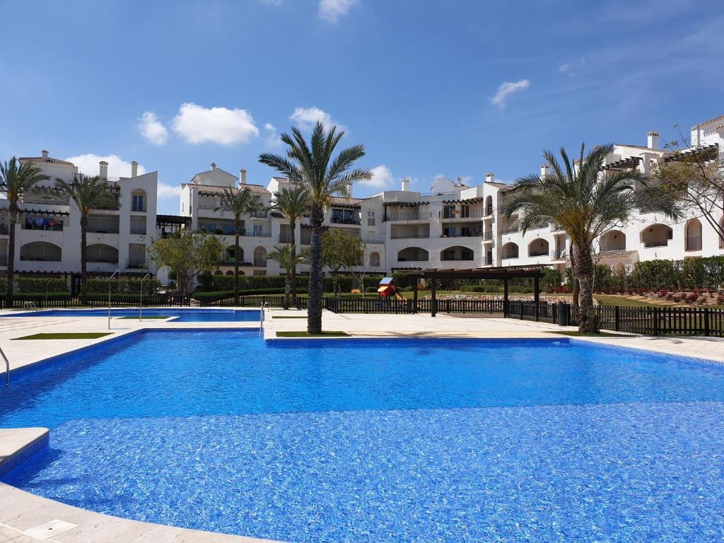 a large blue swimming pool in front of a building at Casa Bacaladilla - A Murcia Holiday Rentals Property in Roldán