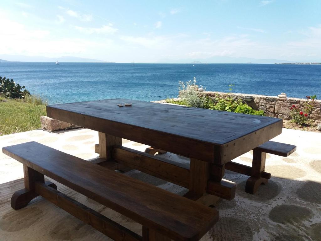 una mesa de picnic de madera con vistas al océano en Ithaca, en Perdika