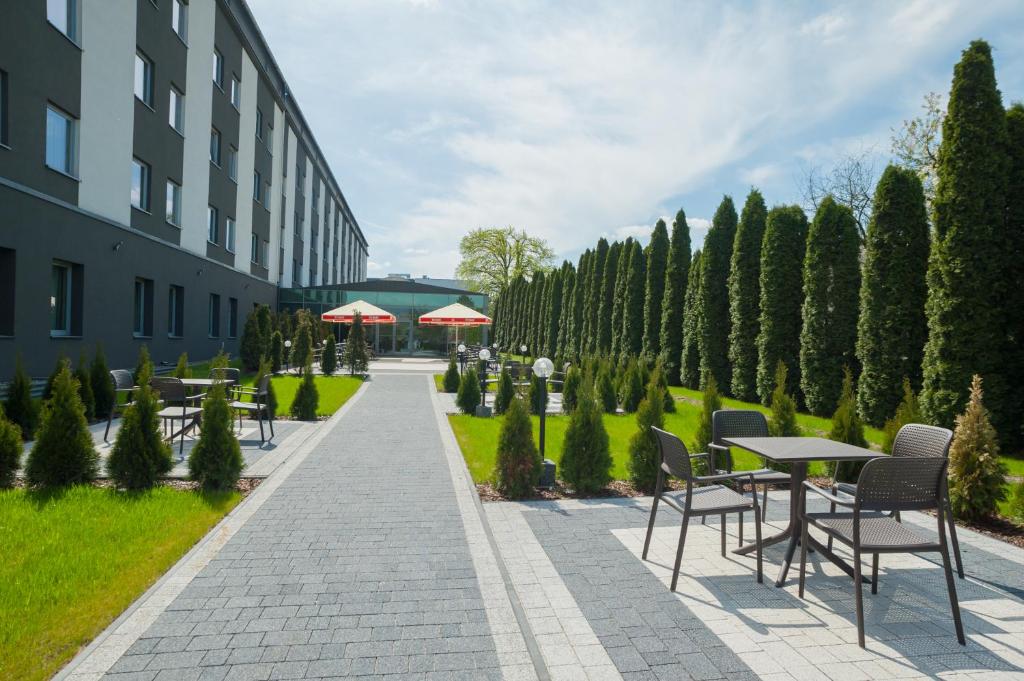 a courtyard with tables and chairs next to a building at Express Kraków Hotel in Kraków