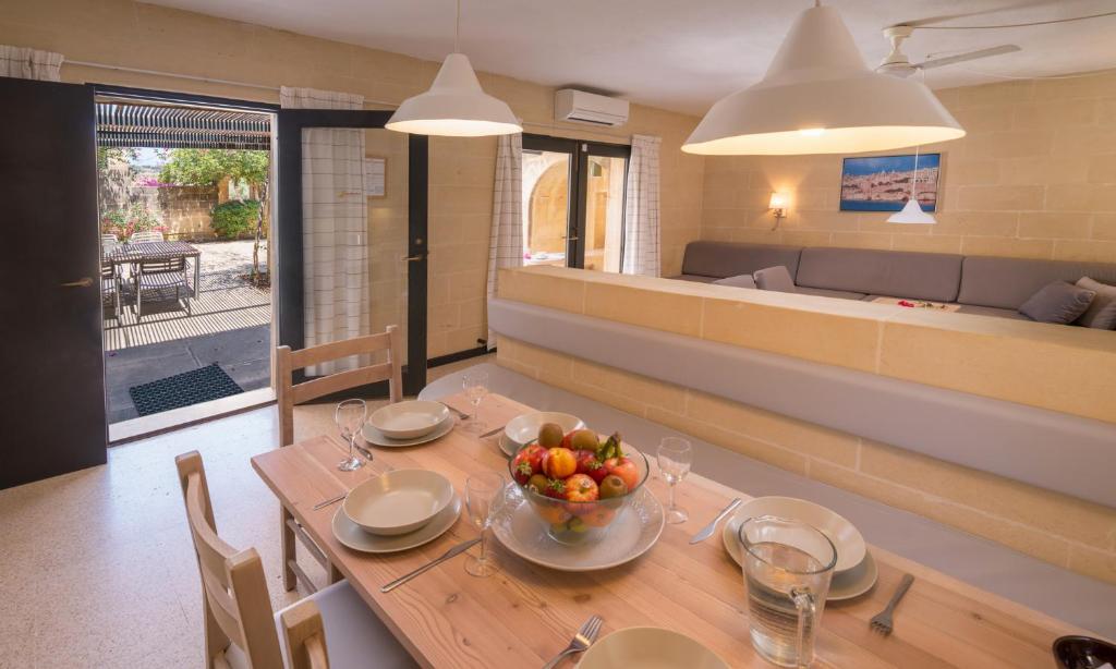 a dining room with a table with a bowl of fruit on it at Mellieha Holiday Centre in Mellieħa