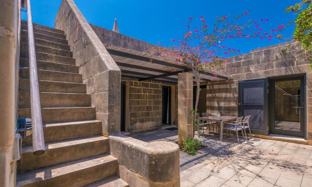 a stone house with a patio with a table at Mellieha Holiday Centre in Mellieħa