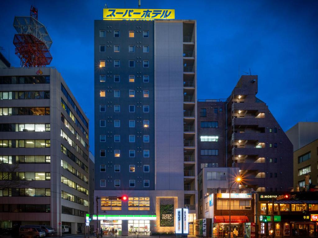 wysoki budynek w mieście w nocy w obiekcie Super Hotel Yokohama Kannai w mieście Jokohama