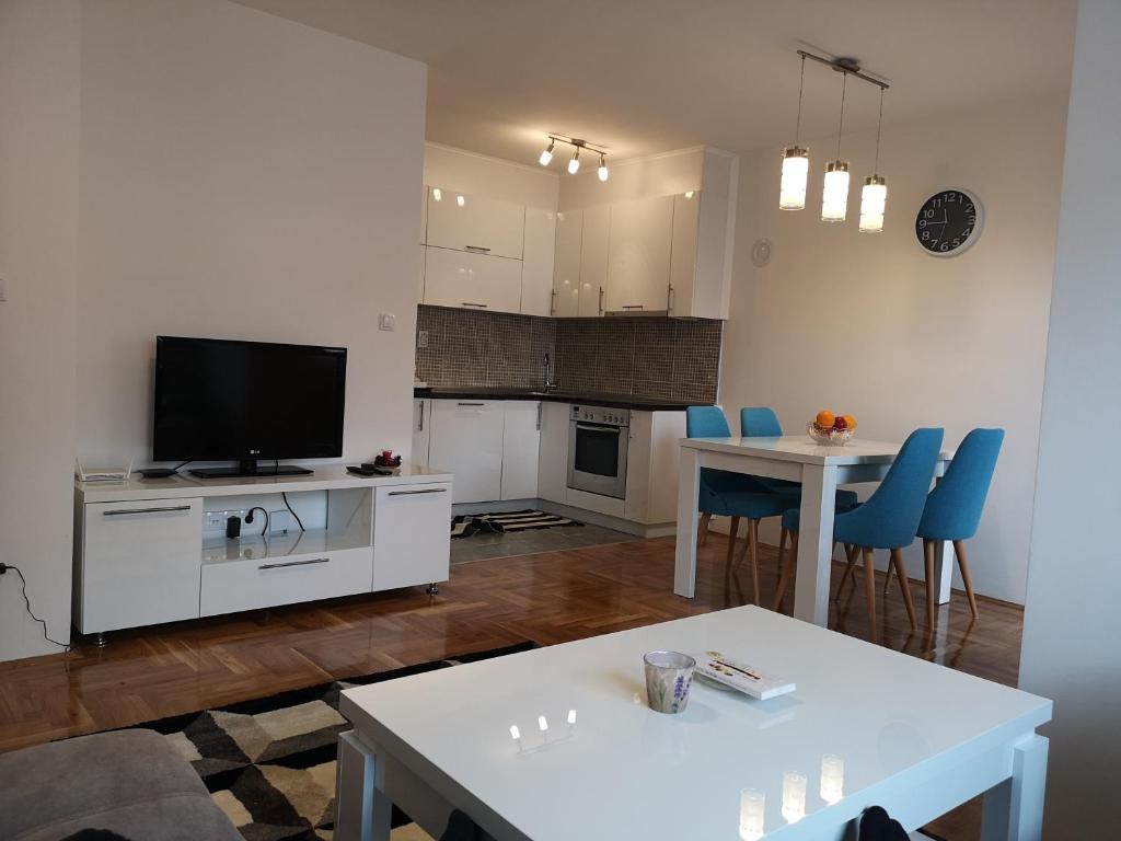 a living room with a television and a table and chairs at Apartman Gaga in Lukavica