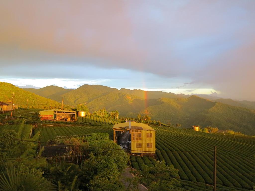 a view of a farm with mountains in the background at Alishan B&amp;B YunMinGi in Fenqihu