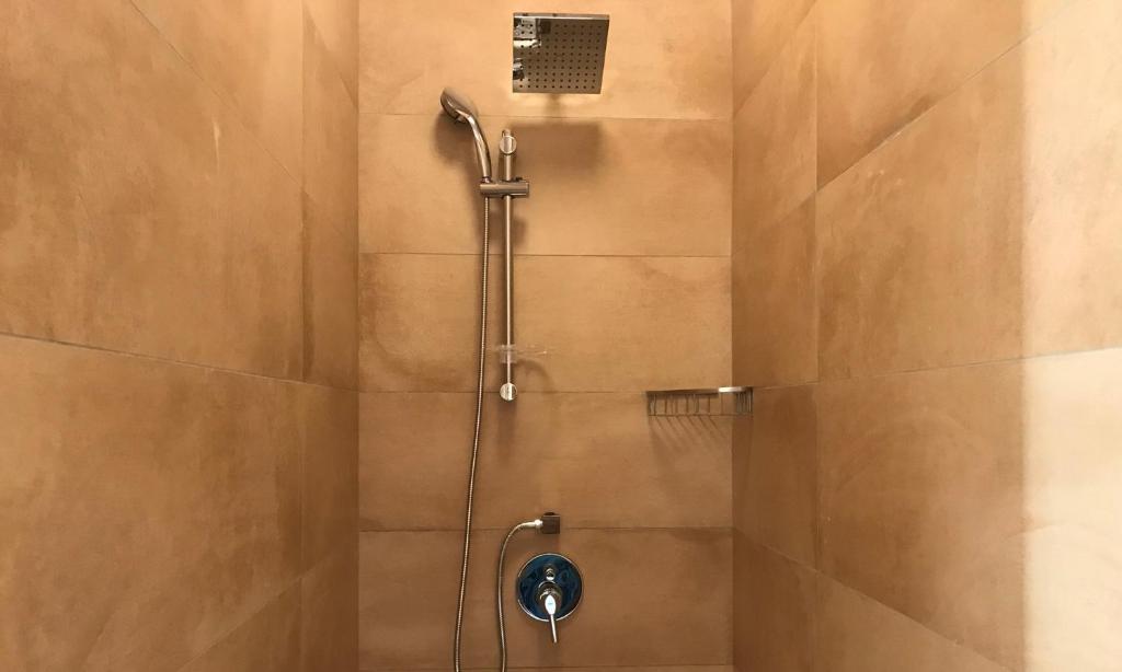 a shower with a shower head in a bathroom at Mellieha Holiday Centre in Mellieħa