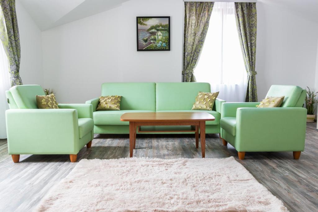 - un salon avec deux canapés verts et une table dans l'établissement Apartments Nasini, à Plovdiv