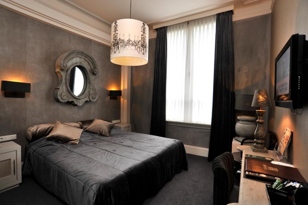 a bedroom with a bed and a mirror on the wall at Villa Rubenshof in Helmond