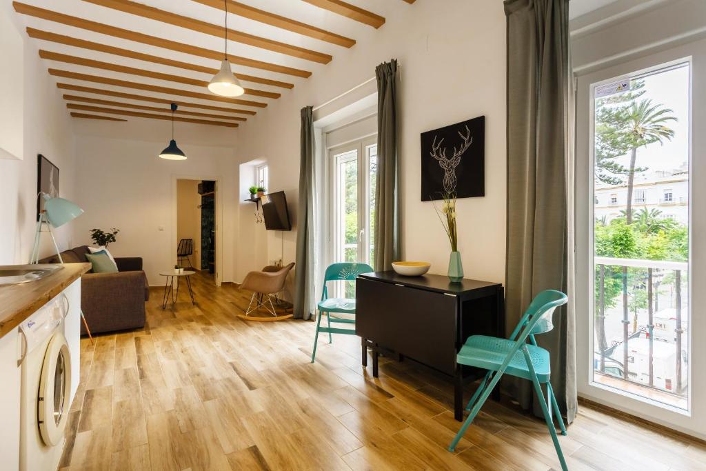 ein Wohnzimmer mit Tisch und Stühlen in der Unterkunft Balcones de CANDELARIA by Cadiz4Rentals in Cádiz