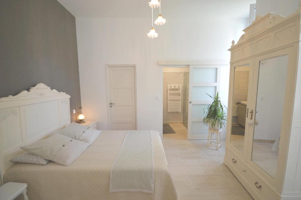 - une chambre blanche avec un lit blanc et un miroir dans l'établissement Chambre d'hôtes à TOUL centre ville avec parking privé, à Toul