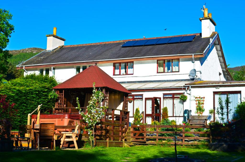 a white house with a table and chairs in front of it at Ardlogie Guest House in Aviemore