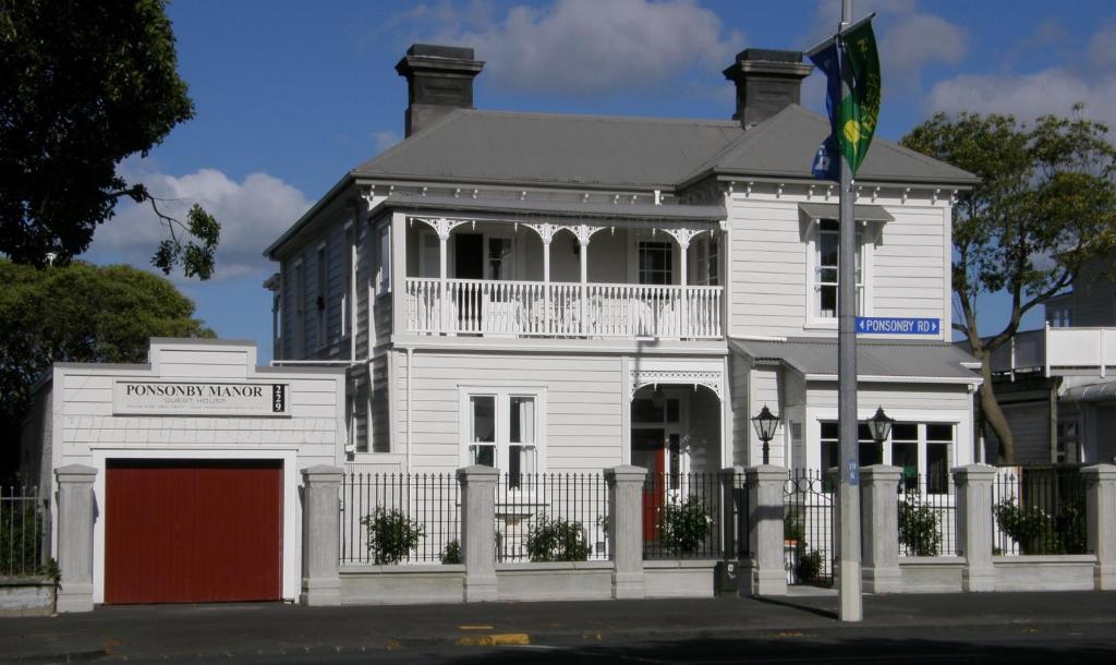 a large building with a flag on the front of it at Ponsonby Manor Guest House in Auckland