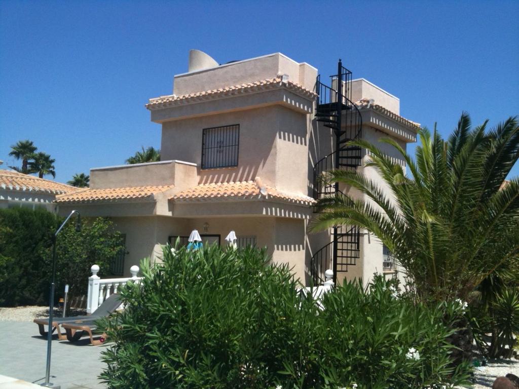ein großes Gebäude mit einem Balkon und einer Palme in der Unterkunft 17 Vistamar Playa Flamenca in Playa Flamenca