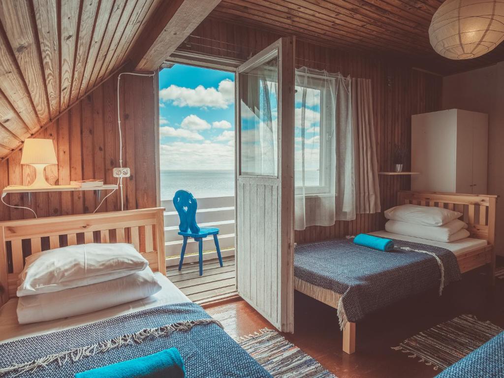 a bedroom with two beds and a balcony with the ocean at Guboja in Nida