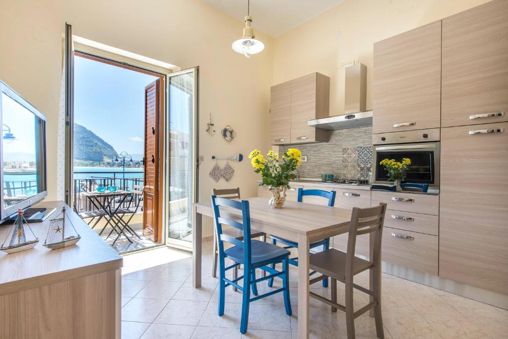 kuchnia ze stołem i krzesłami z widokiem w obiekcie Casetta Vista Mare in Piazza a Mondello w mieście Palermo
