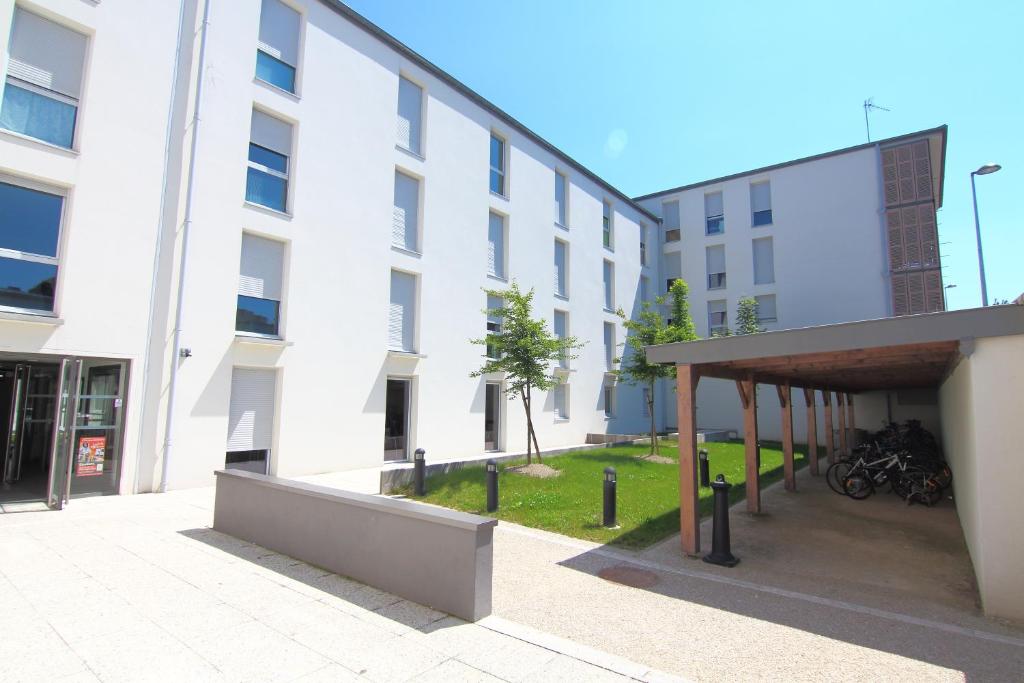 a large white building with a courtyard in front of it at Résidence Hôtelière Laudine in Reims