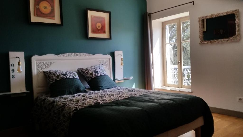 a bedroom with a bed with blue walls and a window at clos st Joseph in Oullins