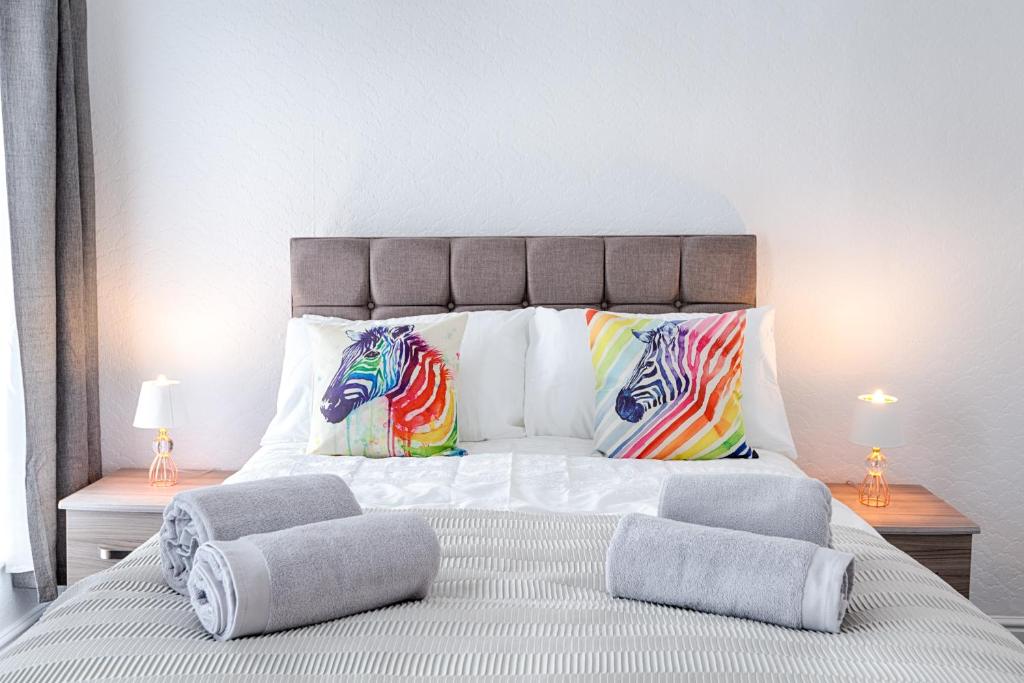 1 dormitorio con 1 cama grande y almohadas coloridas en Fantastic Location - TV in Every Bedroom!, en Swansea