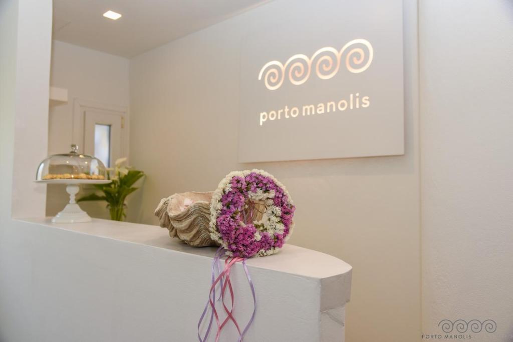 a white counter with a bouquet of flowers on it at Porto Manolis in Agios Ioannis Tinos