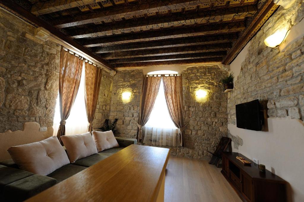 uma sala de estar com um sofá e uma mesa de madeira em Desiderata Studio Apartment em Split