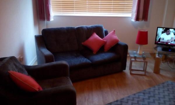 a living room with a couch and a television at Rose of Sharon Retreat in Largs