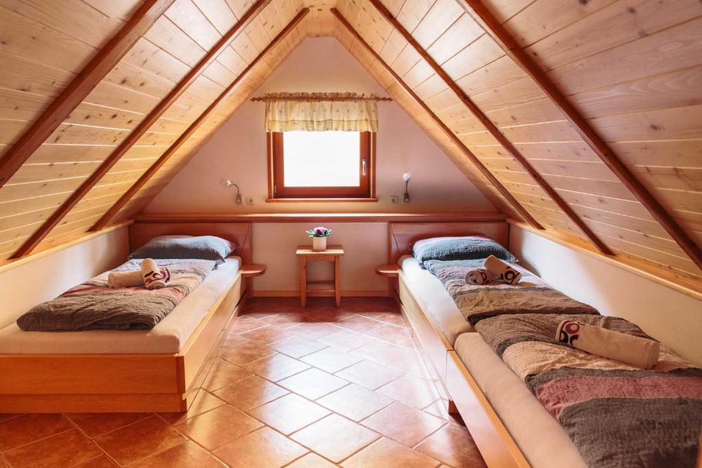 een zolderkamer met 2 bedden en een raam bij Holiday house Pokrovec - Bohinj in Bohinj
