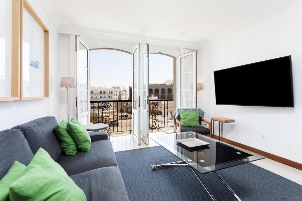 uma sala de estar com um sofá e uma televisão de ecrã plano em Rooms & Suites Balcony 3C em Arrecife