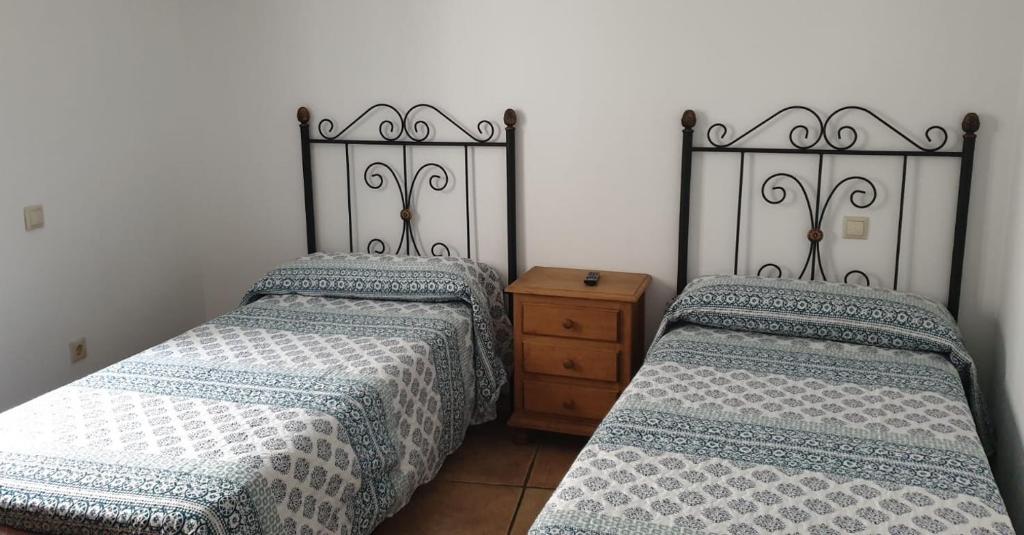 dos camas sentadas una al lado de la otra en un dormitorio en Pensión STOP en El Cubillo de Uceda