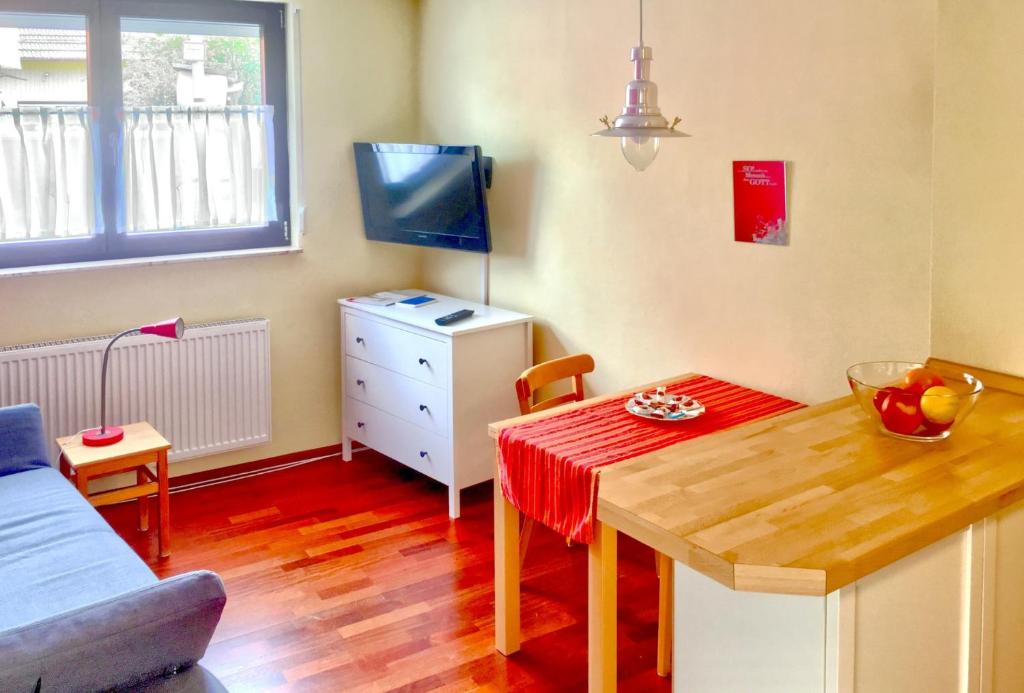 a small living room with a table and a tv at Ferienwohnung Mäder in Schaafheim