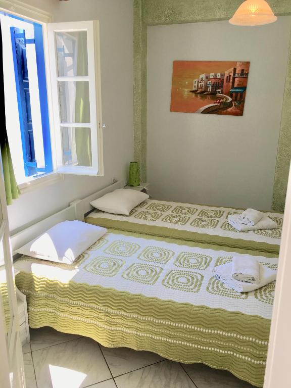 two beds sitting in a room with a window at Pension Sofia Amorgos-Katapola in Katapola