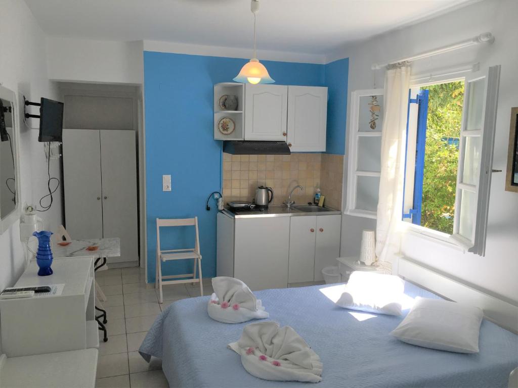a blue room with two beds and a kitchen at Pension Sofia Amorgos-Katapola in Katapola