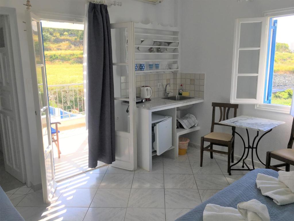 a room with a kitchen with a table and a counter at Pension Sofia Amorgos-Katapola in Katapola