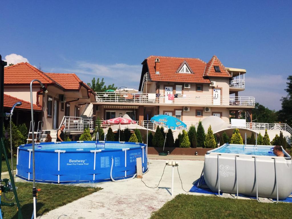 a house with two pools in front of a house at Sobe Srebrno Jezero in Veliko Gradište