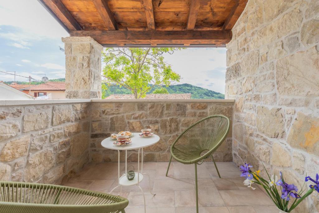 a patio with a table and chairs and a window at Casa di nonno Giovanni in Buzet