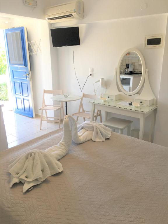 a bedroom with a bed with a mirror and a table at Pension Sofia Amorgos-Katapola in Katapola