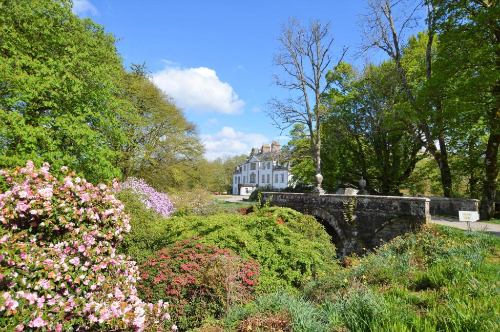 een tuin met bloemen en een gebouw op de achtergrond bij Rhoda`s Cottage in Creggans